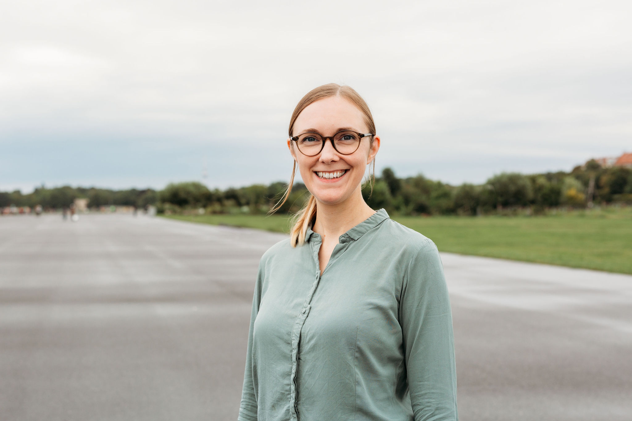 Steph Kunold lächelnd auf dem Tempelhofer Feld in Berlin.