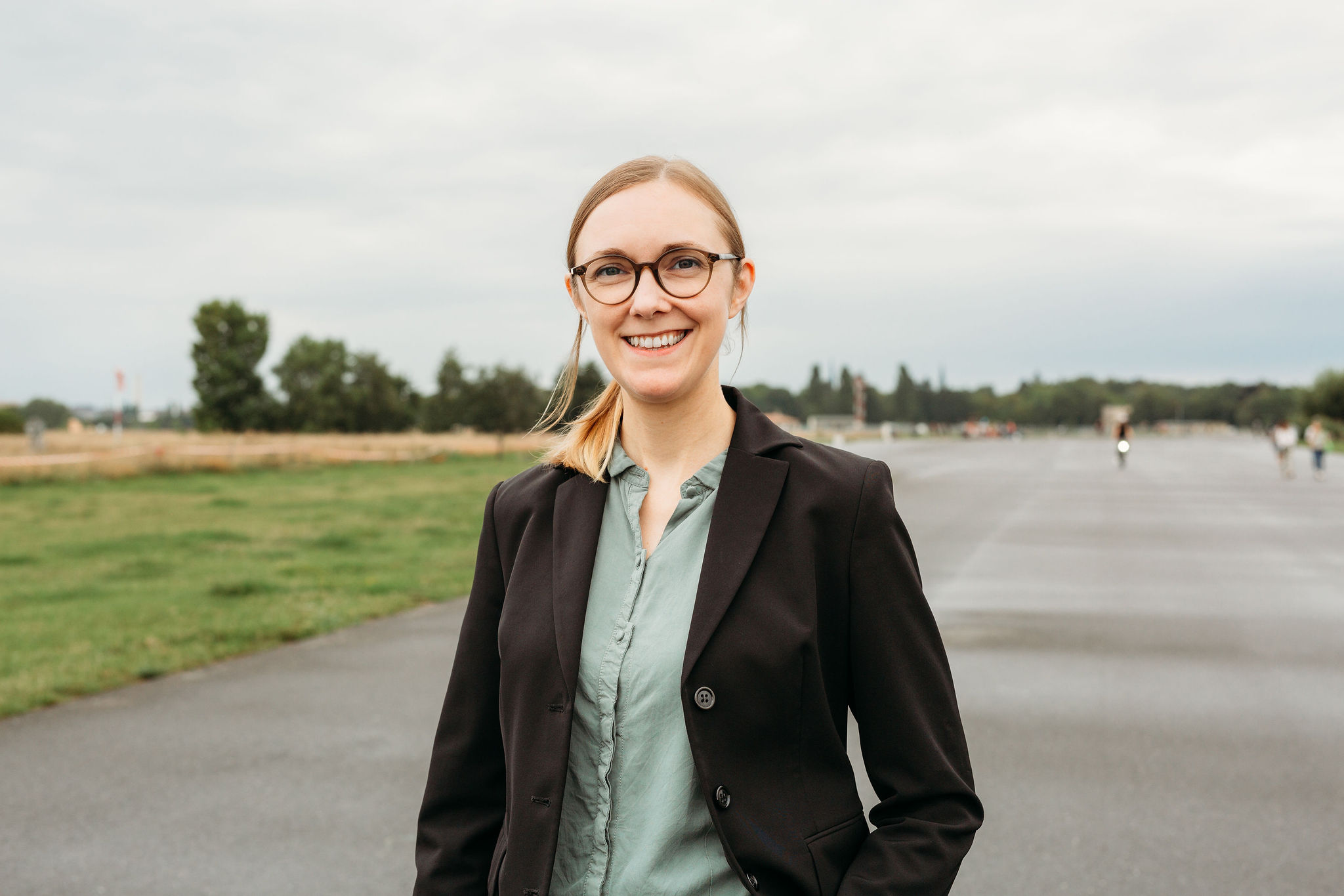 Steph Kunold lächelnd auf dem Tempelhofer Feld in Berlin.